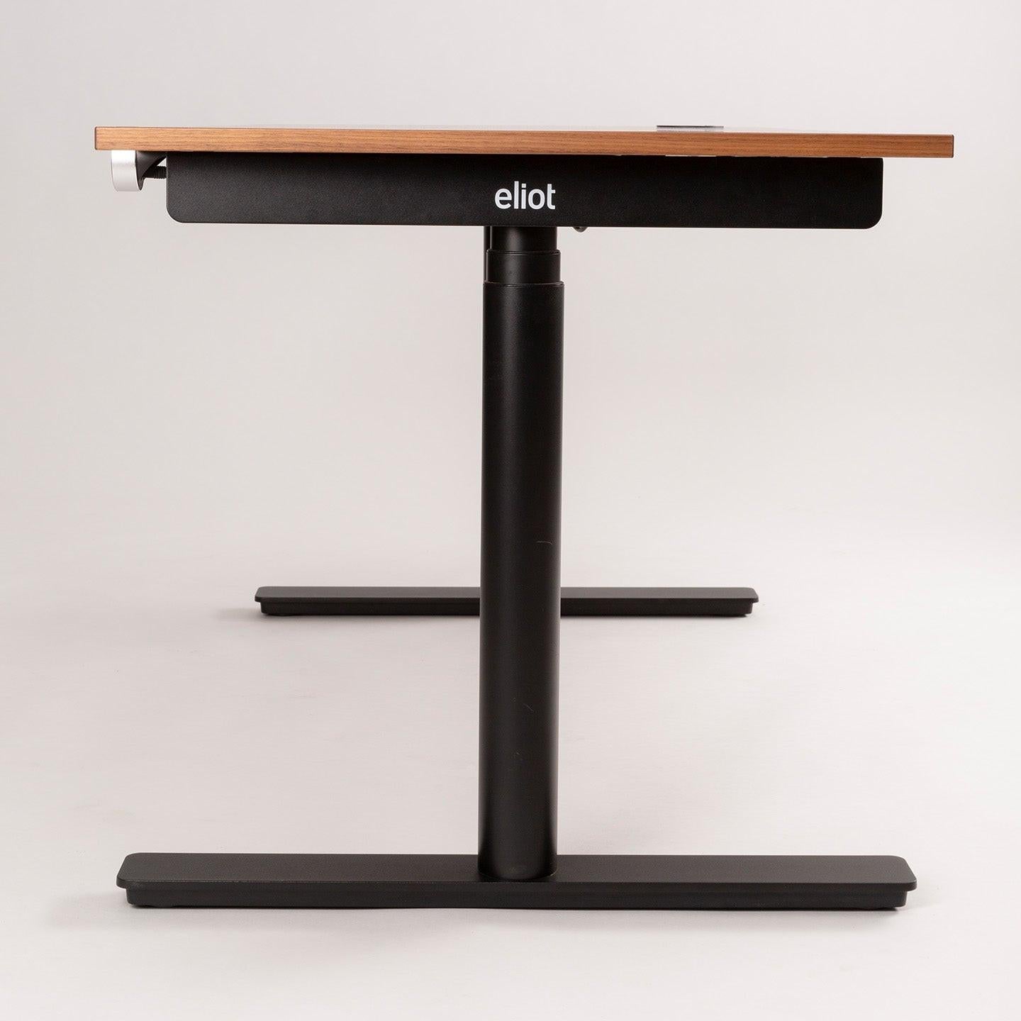 Der höhenverstellbare Schreibtisch MAX von CUBE Products & Furniture hat eine Tischplatte aus Holz, schwarze Metallbeine und ist ideal für Großraum-Workspaces oder XL-Setups mit mehreren Monitoren. Das CUBE-Logo ist an der Vorderkante des Tisches angebracht.