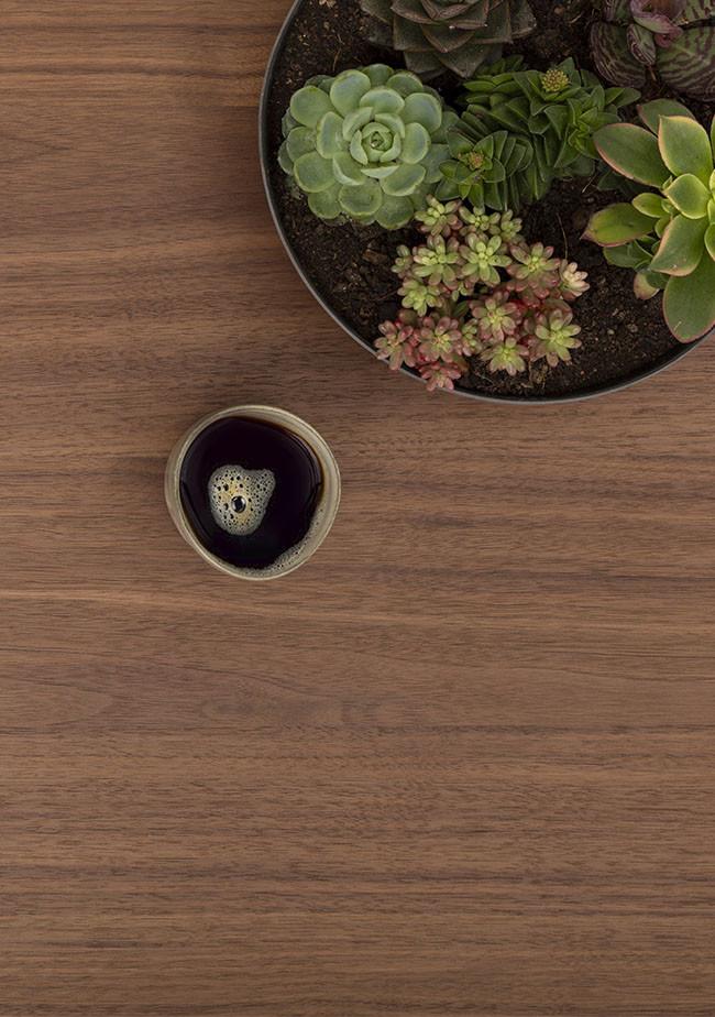 Die Glastasse FOCUS von CUBE Products & Furniture verleiht Ihrem schwarzen Kaffee neben einer runden, saftigen Kanne einen stilvollen Touch - ideal für kompakte Arbeitsbereiche oder gemütliche Home-Office-Einrichtungen.