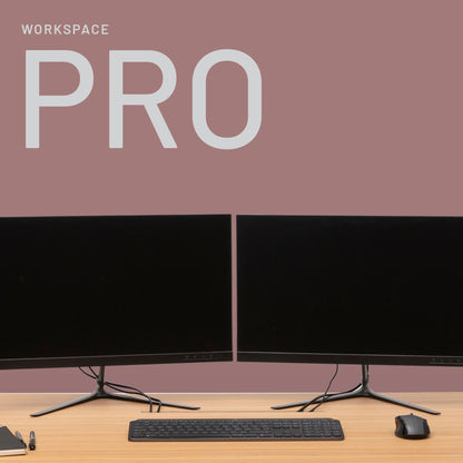A minimalist workspace with two black monitors, keyboard, mouse, pen, and paper on a wooden desk. The mauve background and PRO branding set the stage for Fokus und Mission – der perfekte Ort zum Arbeiten.