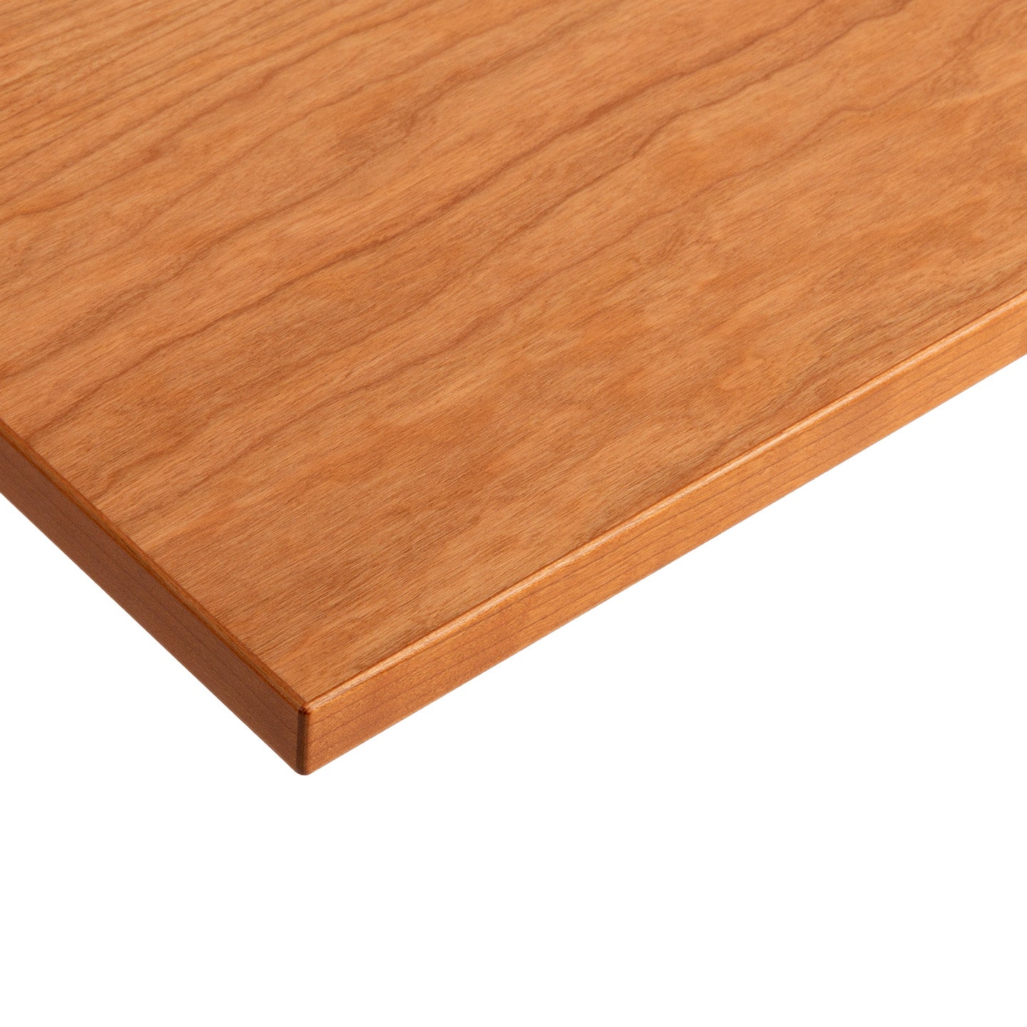 A close-up of the corner of a flat, rectangular Tischplatte - Furnier Kirsche with a smooth, light brown finish and visible wood grain patterns, made in Germany.